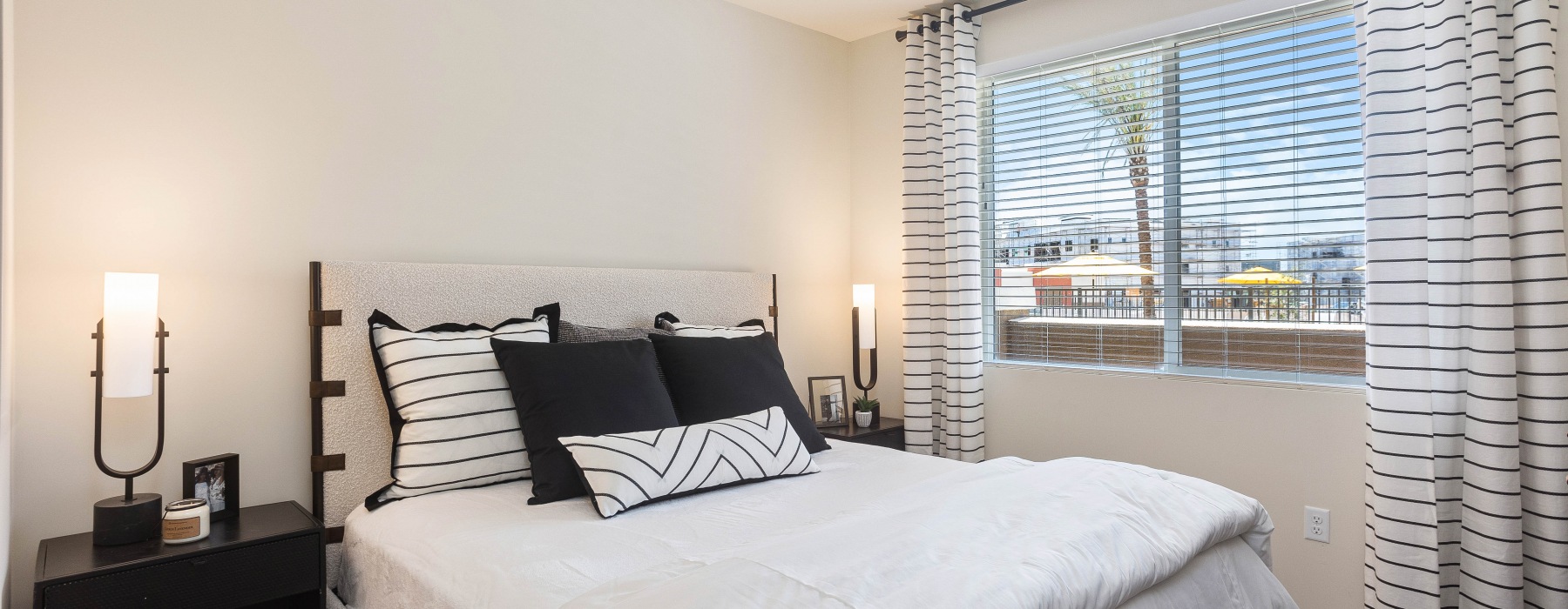 Primary Bedroom with bedframe, large window light fixture